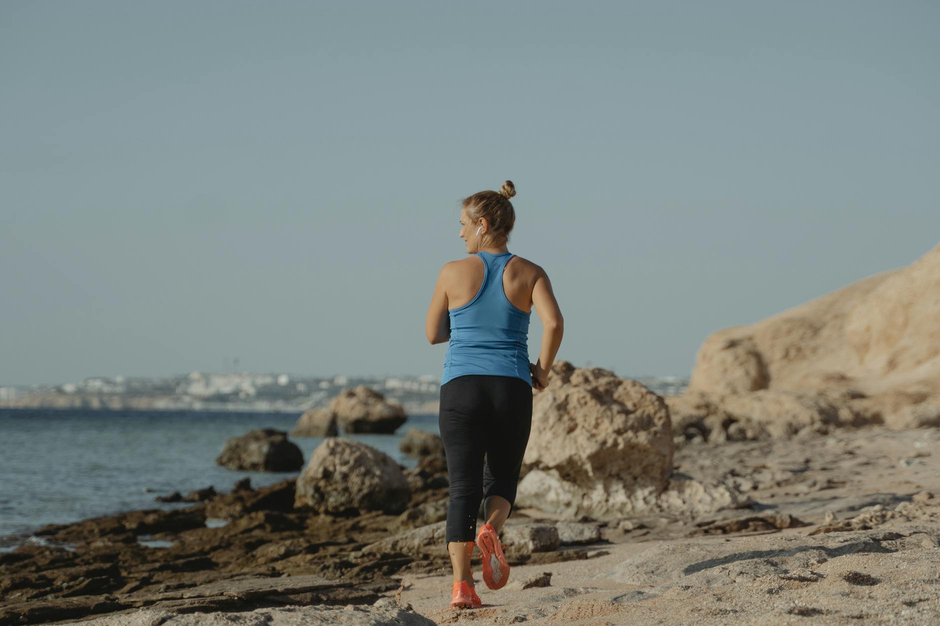 mujer de mediana edad corriendo en la playa